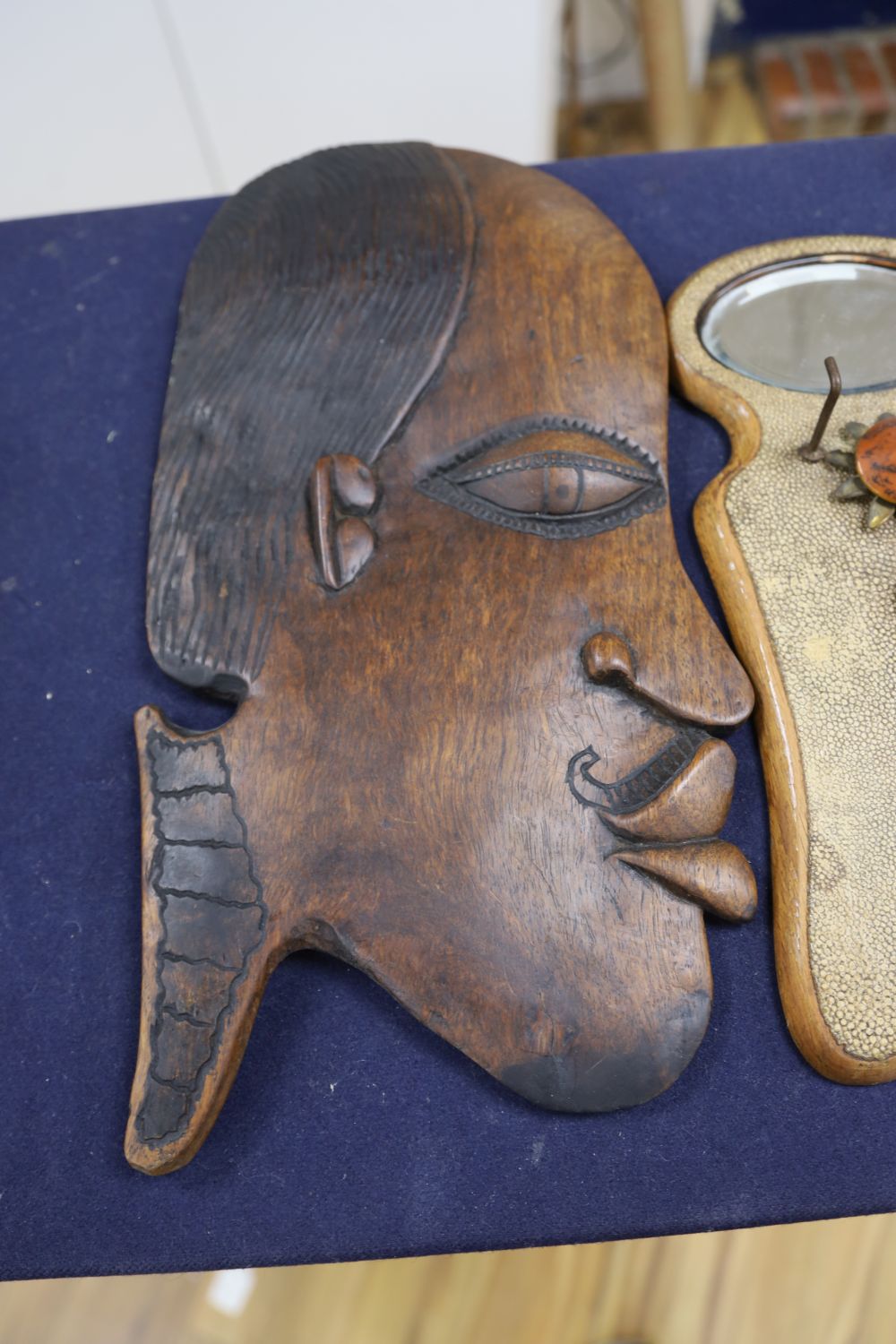 Two carved wooden face masks and a shagreen mirror